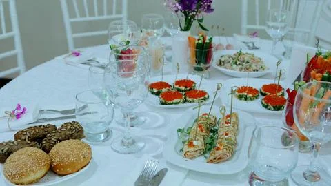 Luxurious round dining table displaying elegant appetizers, red caviar, canapes Stock Photos