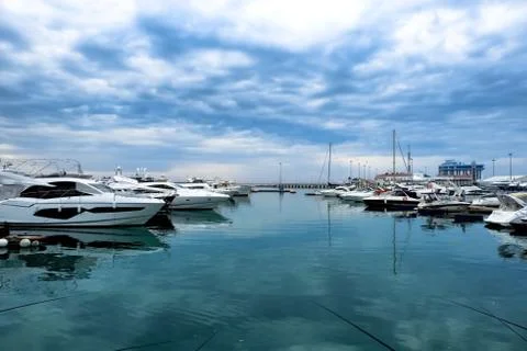 A luxurious view of the sea with a reflection of the clouds. Moored white yac Stock Photos