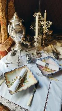 Luxurious vintage table setting with a silver samovar, candles and antique Stock Photos