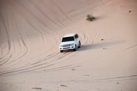 Luxurous white SUW all wheel drive 4x4 on desert safari on dunes exreme racing Stock Photos