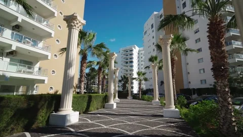 Luxury apartment complex with palm-lined pathway, sunny weather, high-rise Stock Footage 268621215