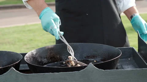 Luxury banquet table under the open air, chef frying food in cauldron for Stock Footage 225521700