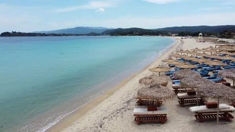 Luxury Beach Resort Shoreline with Rows of Sunbeds and Parasol Umbrellas Stock Footage 346568370