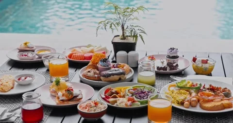 Luxury breakfast spread served by swimming pool Stock Footage 340548320