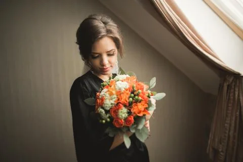 Luxury bride in black robe posing while preparing for the wedding ceremony Stock Photos