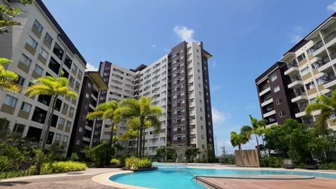 Luxury Condominium with Swimming Pool and Palm Trees under Blue Sky Stock Footage 317879334