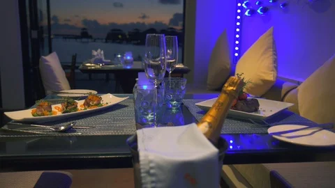 A luxury fine dining table dinner setting with champagne and meals served. Stock Footage 86720274