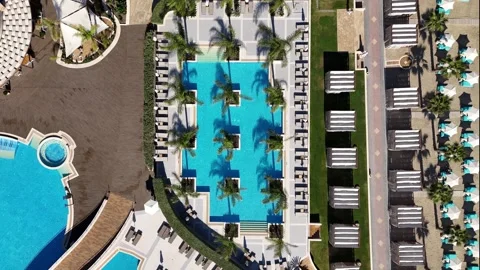 Luxury hotel pool complex with palm trees and beach zone, Greece Stock Footage 327665199