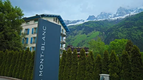 Luxury hotel resort in Chamonix surrounded by green nature and mountains. Stock Footage 247251731