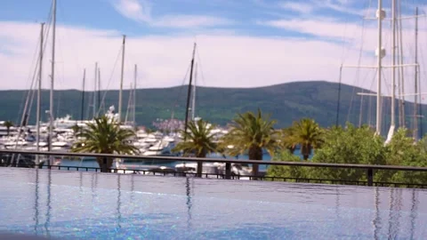 Luxury infinity pool with blurred background of yachts and palms 스톡 동영상 333688747