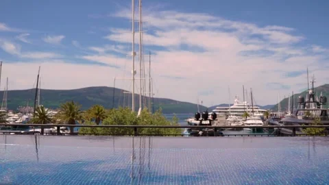 Luxury infinity pool with blurred background of yachts and palms Stock Footage 333688749