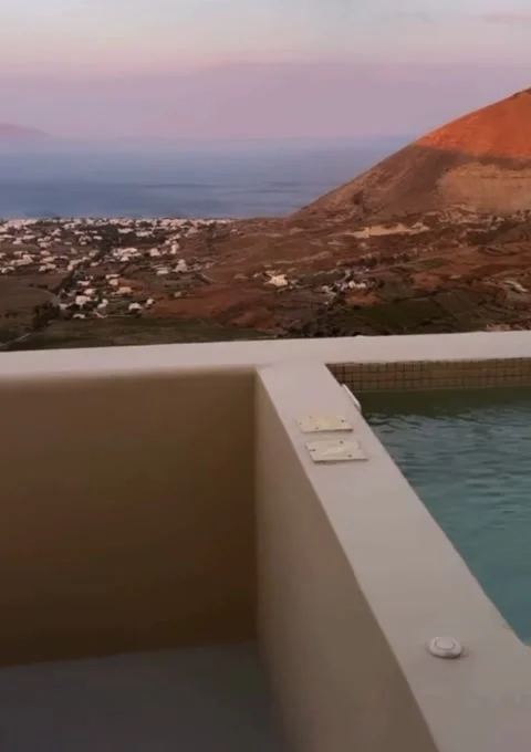Luxury Infinity Pool Overlooking Coastal Hills and Sea at Pink Sunset Stock Footage 336924747