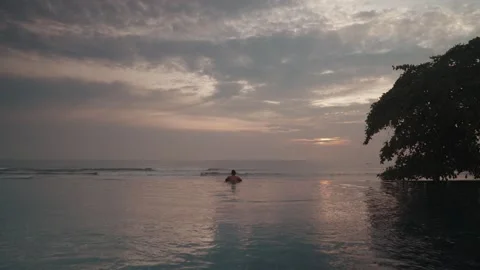 Luxury infinity pool at sunset in Bali with man relaxing ocean view Видео 331063851