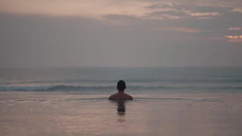 Luxury infinity pool at sunset in Bali with man relaxing ocean view Vidéo 331066953