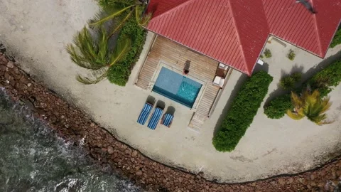 Luxury Island Suite Infinity Pool With Female Walking Out Drone Shot 스톡 동영상 236165710