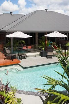 Luxury looking waterside with round shape pool beside a hotel Stock Photos