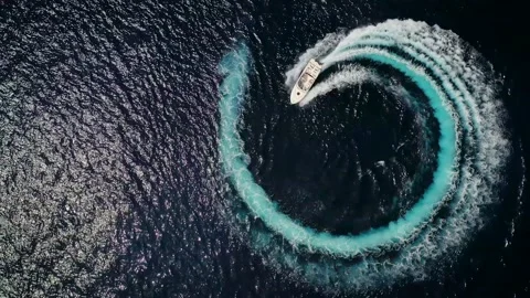 Luxury motor boat forms a circle of waves and bubbles Video stock 158753864