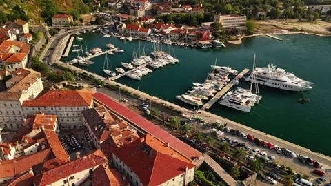 Luxury Motor Yachts Berthed Below a Town Wall Aerial Track Stock Footage 345529630