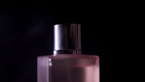 Luxury Perfume Bottle With Silver Cap Amidst Swirling Purple Mist On Black Stock-Footage 330110489