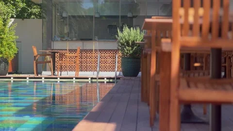Luxury poolside lounge area swimmer in the pool Stock Footage 292922378