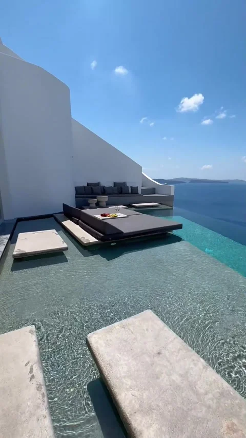 Luxury poolside view in Santorini with blue skies and clear water. Vídeos de archivo 335079644