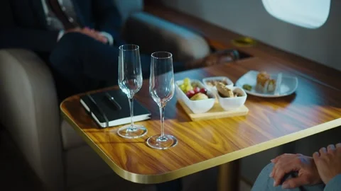 Luxury private jet interior featuring business snacks and champagne glasses.. Stock Footage 337542461
