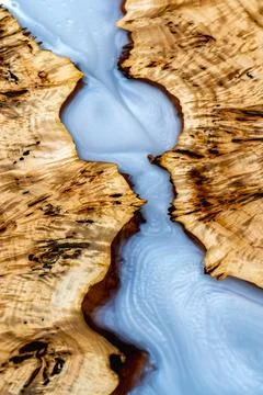 Luxury river table surface with figured burl wood and blue epoxy resin Stock Photos