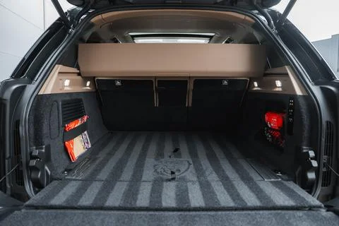 Luxury SUV cargo area in workshop with raised tailgate and beige shelf Foto stock