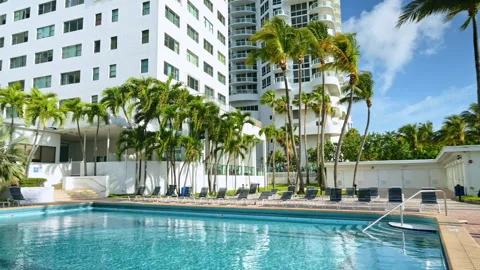 Luxury swimming pool with palm trees and hotel Stock Footage 333411340
