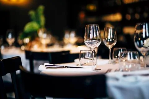 Luxury table settings for fine dining with and glassware, beautiful blurred   Stock Photos