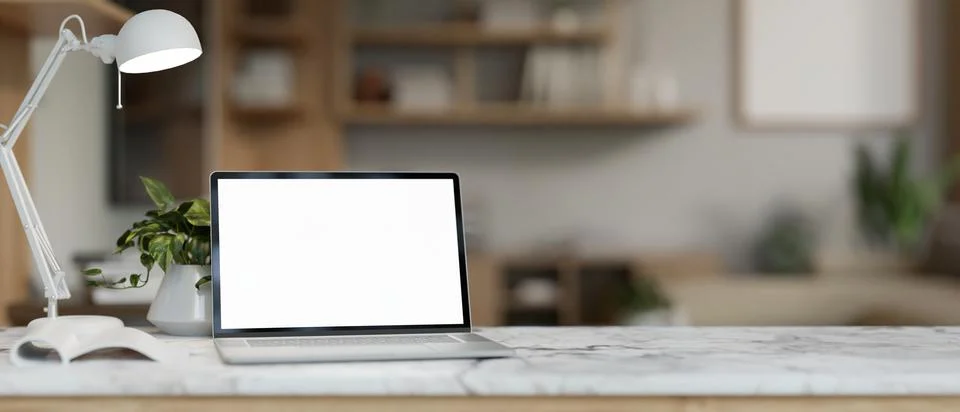 A luxury white marble table features a white-screen laptop computer mockup .. イラスト素材