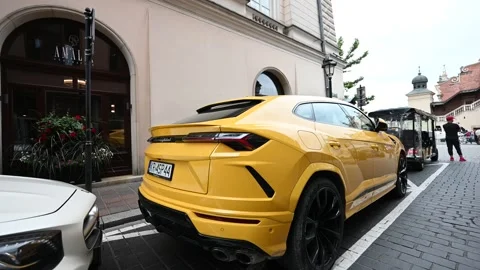 Luxury Yellow Lamborghini Urus SUV Parked on an Old Town Street in Krakow, .. Stock Footage 313871709