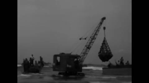 LUZON - 1945 - A tractor-mounted crane unloads supplies from a landing craft, Video stock 264753073