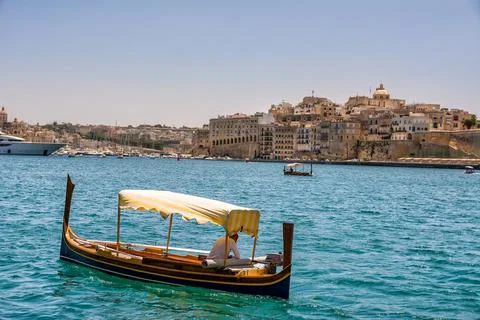 Luzzu, a typical Maltese boat and in the background Vittoriosa in Malta Stock Photos