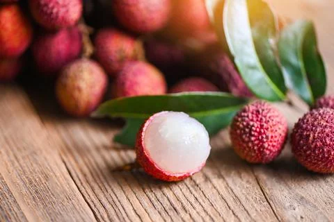 Lychee fruit and green leaf on wooden background, fresh ripe lychee peeled fr Stock Photos