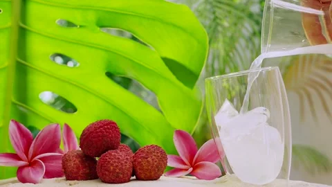 Lychee Juice Pouring Into Iced Cube Double Wall Glass. Stockbeeldmateriaal 196203169