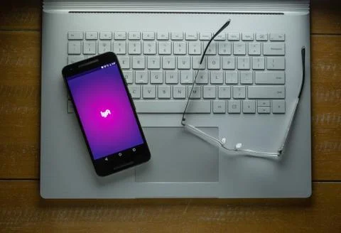 Lyft app loading on Android phone in a dark room Foto stock