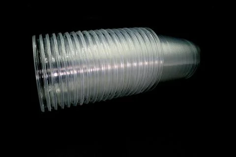 Lying and standing plastic cups isolated on black background. Stock Photos