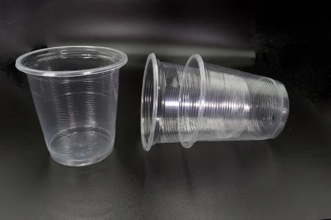 Lying and standing plastic cups isolated on black background. Stock Photos