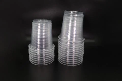 Lying and standing plastic cups isolated on black background. Stock Photos