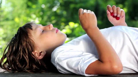 Lying boy eating cherries Stock Footage 24936894