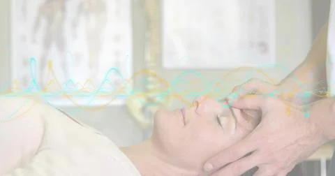 Lying client wearing light top receiving forehead care with pillow at spa, with Stock Photos