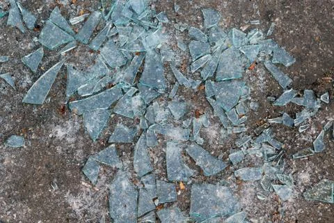 Lying on the ground a lot of sharp fragments of broken glass. Stock Photos
