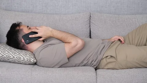 Lying man Talking on the phone Video stock 265797242