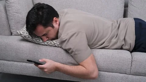 Lying man using smartphone Stock Footage 269129791