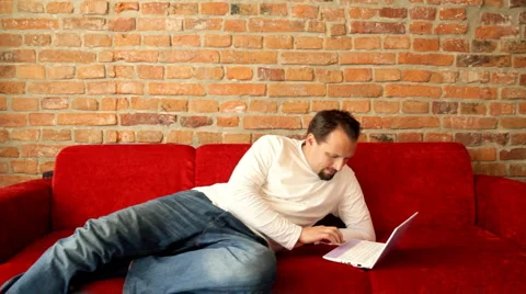 Lying man working on laptop Stock Footage 1214583