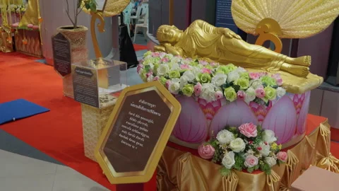 Lying Small Buddha Statue, Golden Body Reclining On Side With Lotus Flowers Stockbeeldmateriaal 249967232