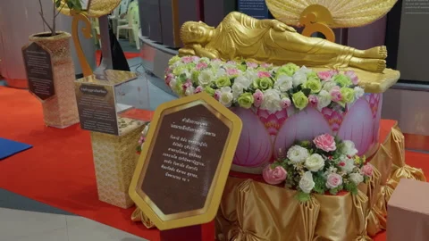 Lying Small Buddha Statue, Golden Body Reclining On Side With Lotus Flowers Stock Footage 249967734