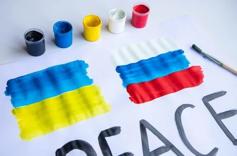 Lying on the table a poster with the flag of Ukraine and Russia Stock Photos