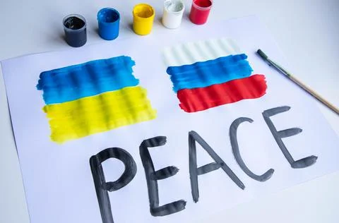 Lying on the table a poster with the flag of Ukraine and Russia Stock-Fotos